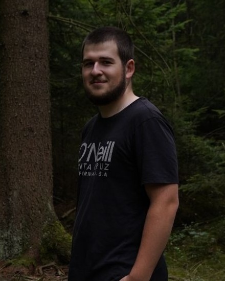 Portrait of Matěj Adamec standing in a forest